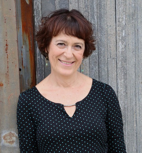 photograph of a smiling woman with short brown hair